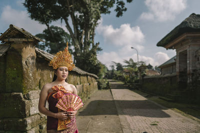 Thoughtful woman wearing traditional clothing standing outdoors