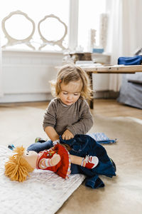 Cute girl playing with doll at home