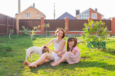 Happy girl playing on grass against built structure