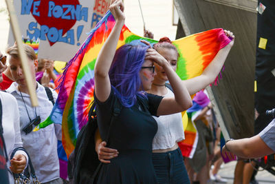 People holding multi colored flags