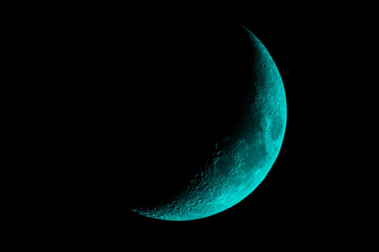 CLOSE-UP OF HALF MOON AGAINST BLACK BACKGROUND