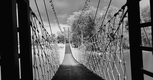 Footpath amidst trees against sky