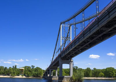 Low angle view of bridge over dnieper river at trukhanov island against sky