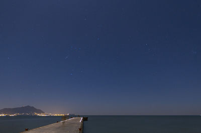 Scenic view of sea against clear blue sky at night