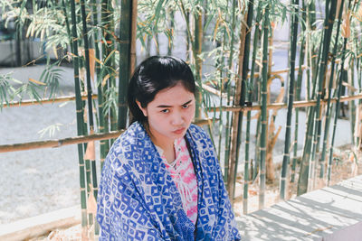 Portrait of woman with scarf against plants