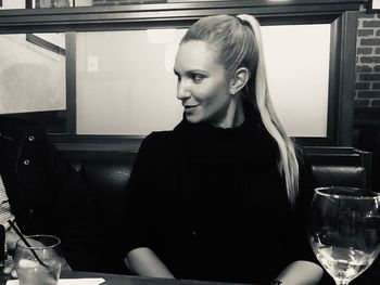 Smiling woman looking away while sitting in restaurant