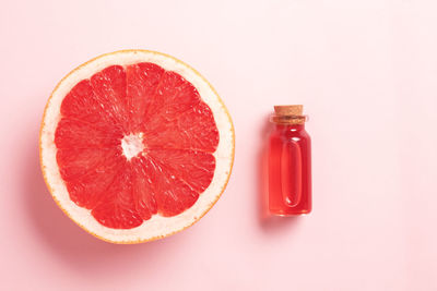 High angle view of orange fruit against pink background