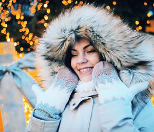 Smiling young woman in warm clothing looking away