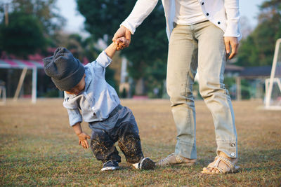 Low section of father and son on field