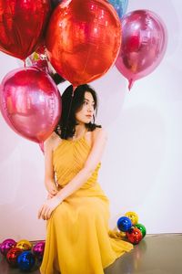 Portrait of a smiling young woman with balloons