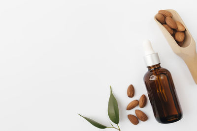 Close-up of hand holding bottle against white background