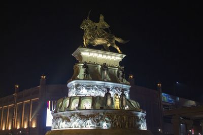 Low angle view of illuminated statue against sky at night