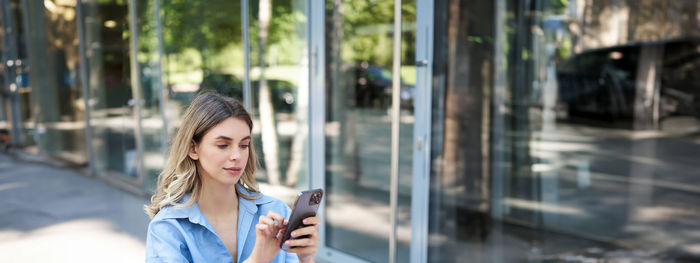 Portrait of young woman using mobile phone