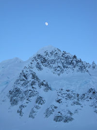 Scenic view of snowcapped mountains against clear blue sky