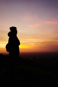 Silhouette man standing against sky during sunset