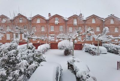 Snow covered houses and buildings against sky