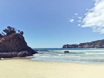 View of calm beach against blue sky