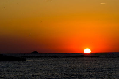 Scenic view of sea against orange sky