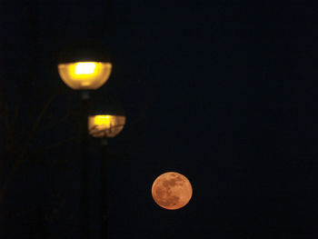 Low angle view of illuminated moon against sky at night