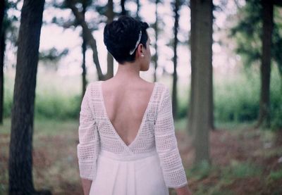 Woman standing by tree in forest