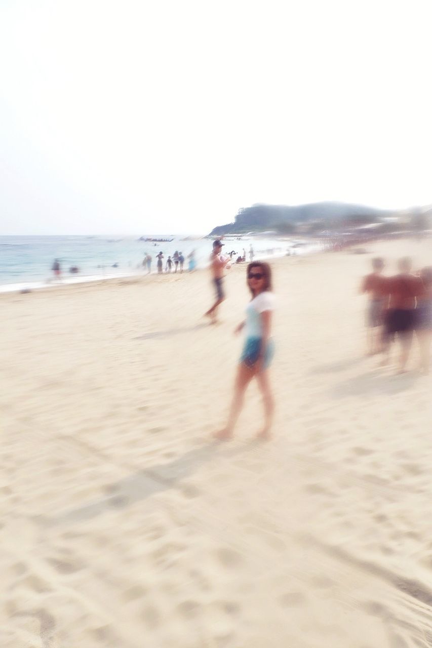 BLURRED MOTION OF PEOPLE WALKING ON BEACH