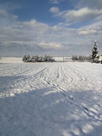 Scenic view of snow covered field against sky