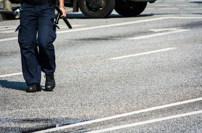 Low section of man walking on road