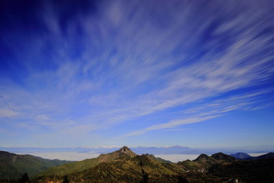 Scenic view of mountains against blue sky