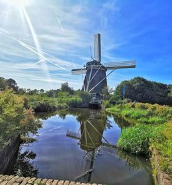 Traditional windmill on landscape against sky