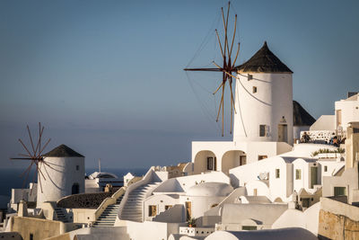 Traditional windmill by building against sky