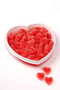 High angle view of red berries in bowl against white background