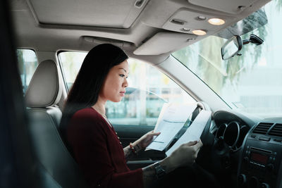 Side view of woman sitting in bus