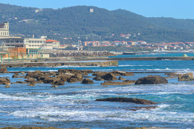 Scenic view of sea by buildings against sky