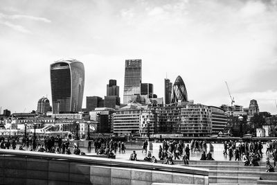 Crowd by 30 st mary axe against sky in city