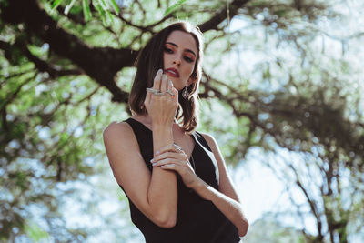 Portrait of woman standing against tree