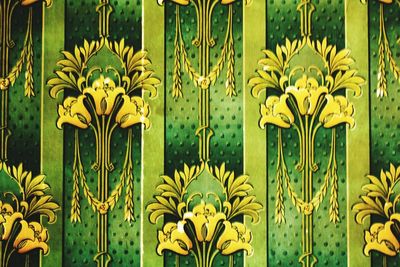 Close-up of yellow flowering plants on metal fence