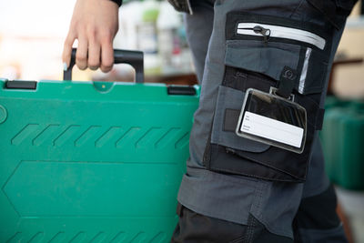 Midsection of man holding suitcase