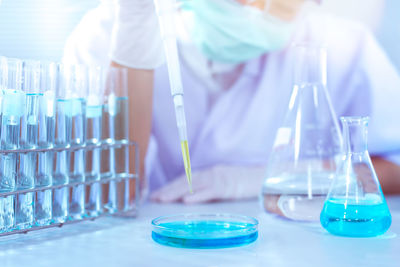 Scientist examining blue chemical in laboratory