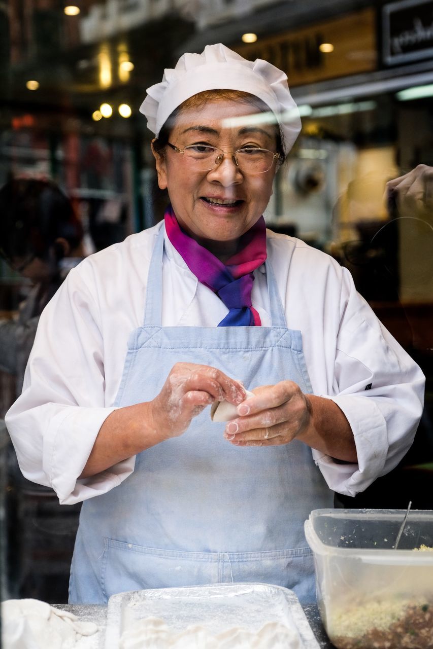 occupation, one person, real people, front view, business, food and drink, waist up, clothing, standing, adult, preparation, holding, working, chef, smiling, men, food, focus on foreground, store, uniform, preparing food, food and drink establishment