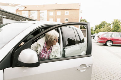 Senior woman sitting in car