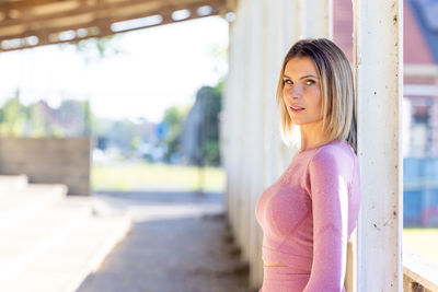 Portrait of young woman standing in city