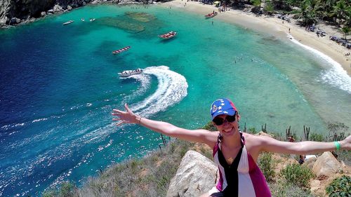 Portrait of happy woman in sunglasses at beach