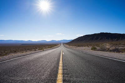 Road amidst landscape against clear blue sky