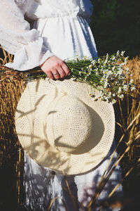 Midsection of woman holding flowers