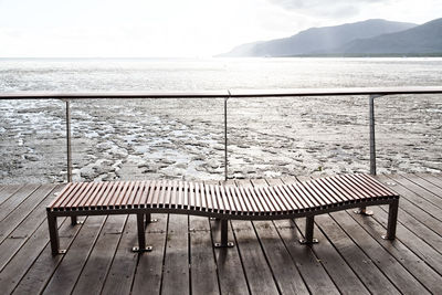 Empty seats in sea against sky