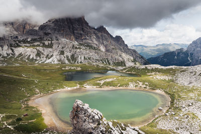 Scenic view of lake by mountains against sky