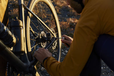 Young cyclist fixing nut on bicycle