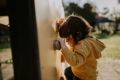 Side view of child climbing wall at playground