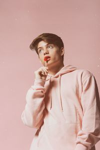 Portrait of young man wearing mask against white background