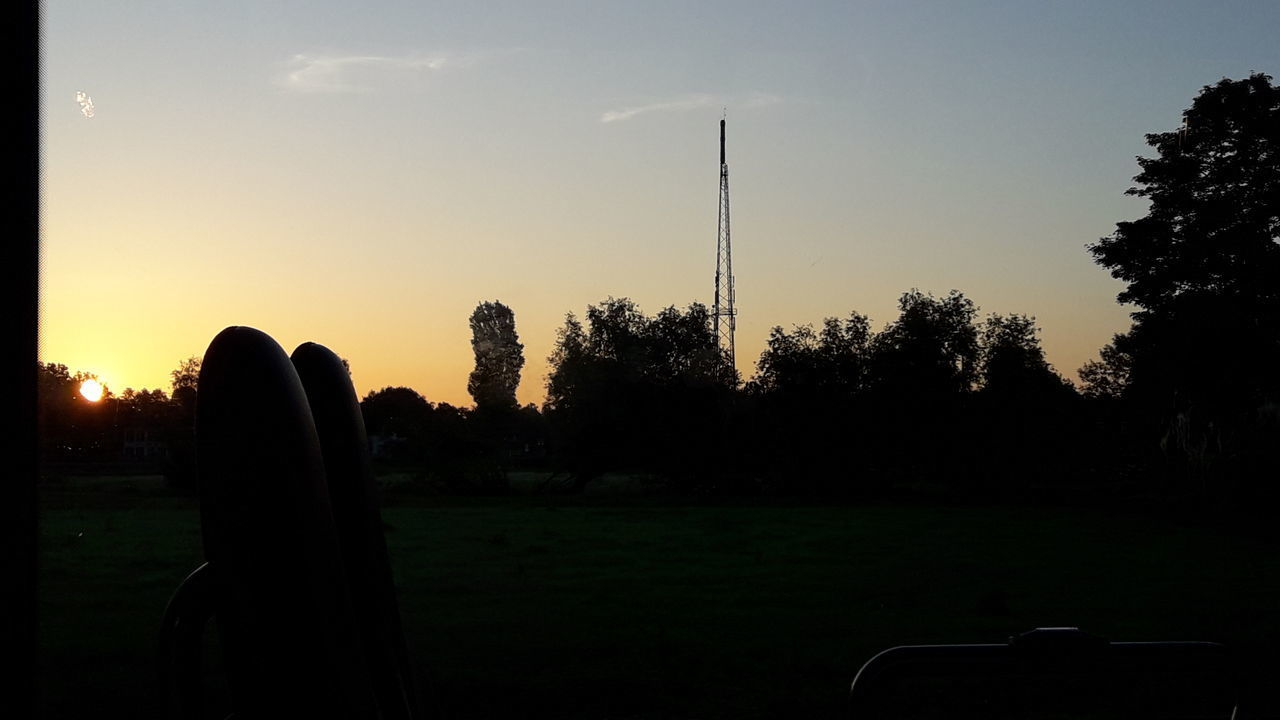 SILHOUETTE OF PERSON ON FIELD AT SUNSET